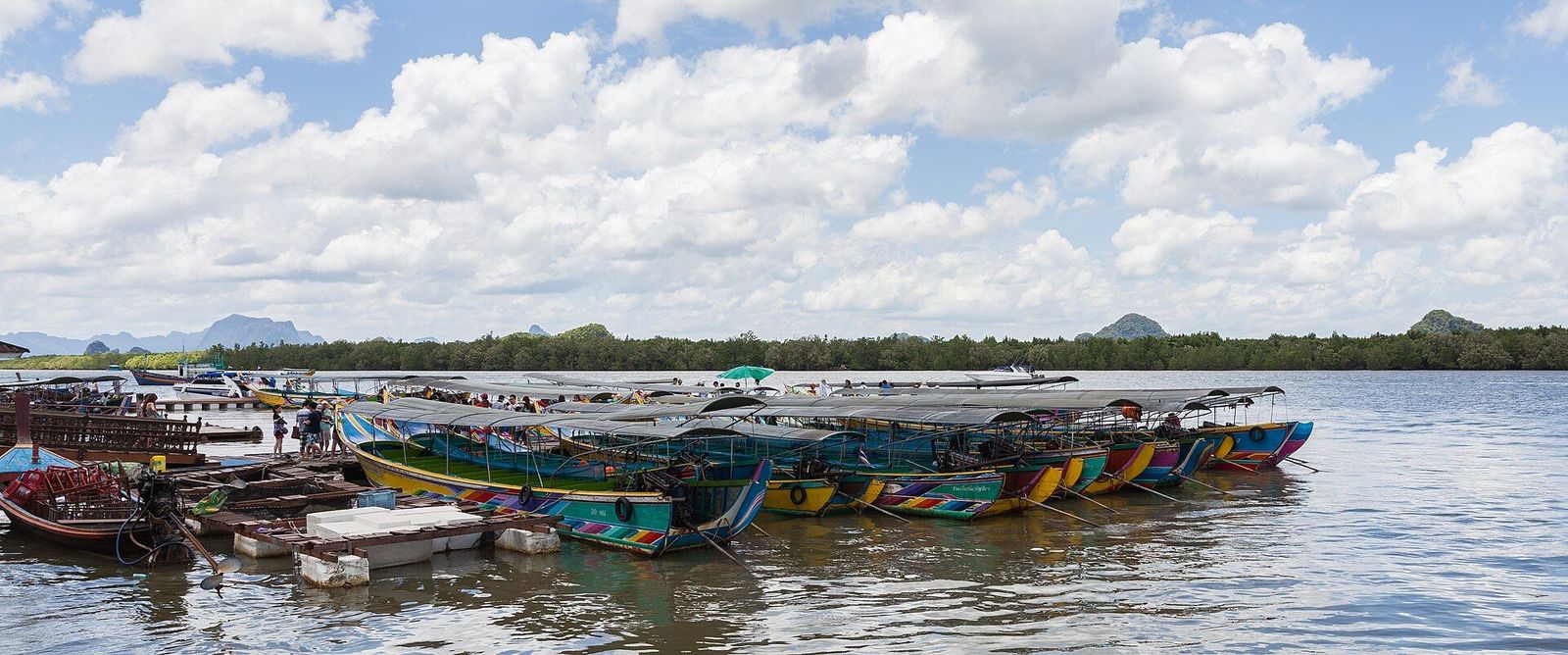 Kleurrijke longtailboten afgemeerd bij een dorp aan de baai van Phang Nga